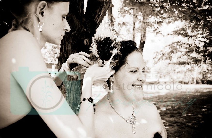 bridesmaid helping switch out brides veil