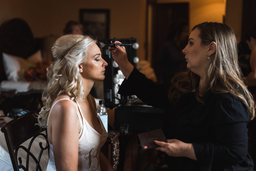 Bride getting into makeup