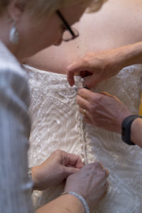 getting bride into her wedding dress