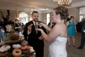bride and groom eating donuts