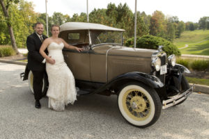 bride and groom by old car